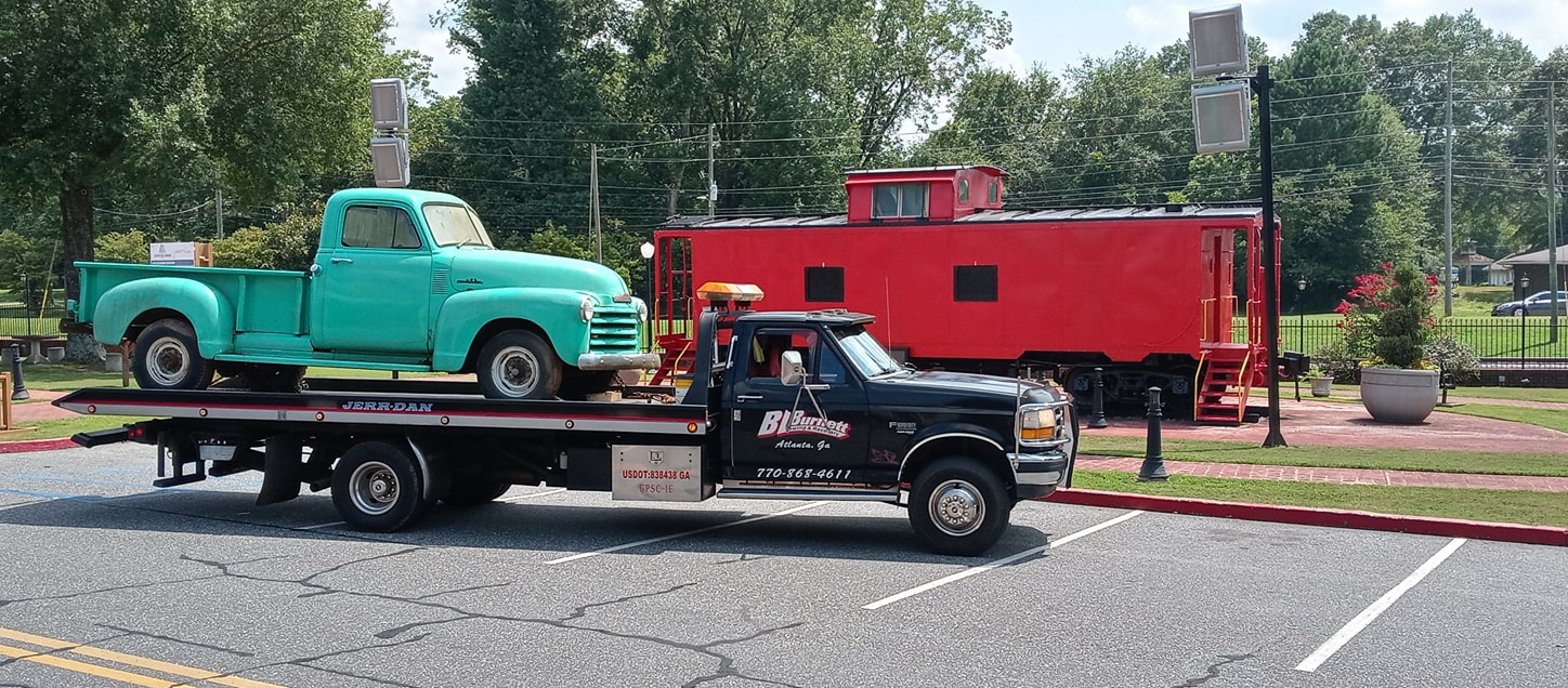 green truck on black bl burnett tow truck.
