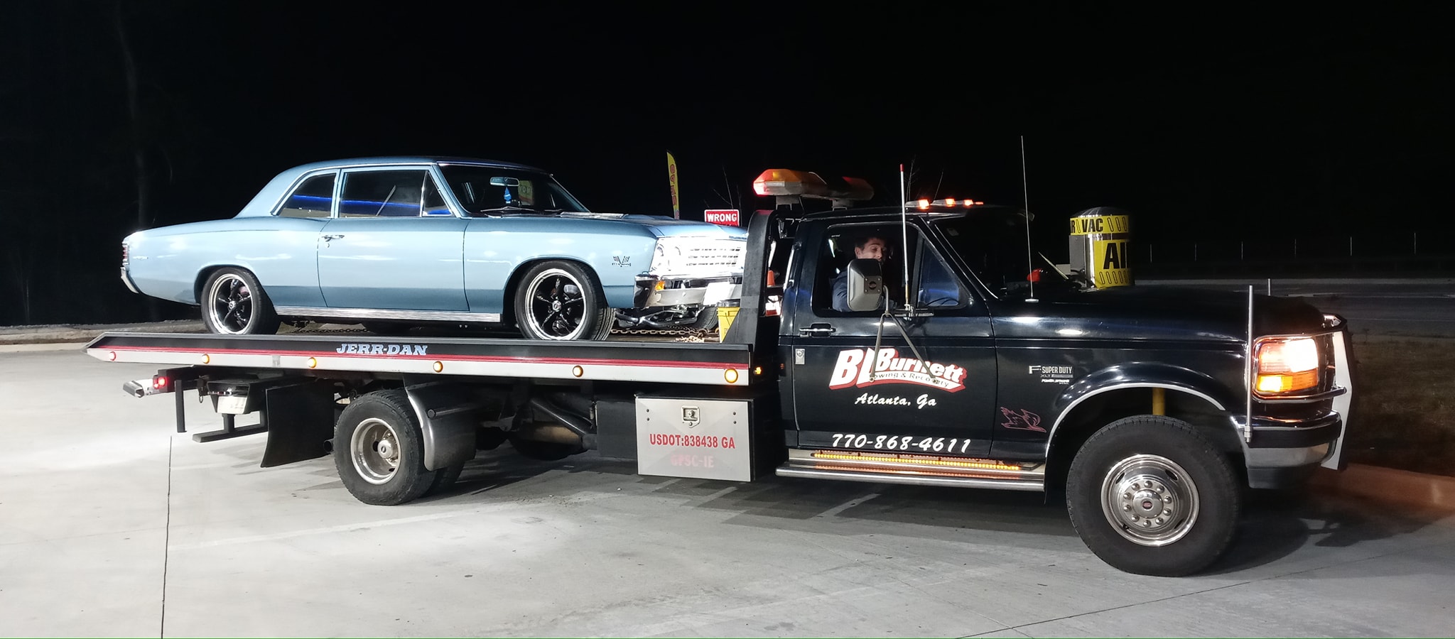 blue car on back of bl burnett tow truck