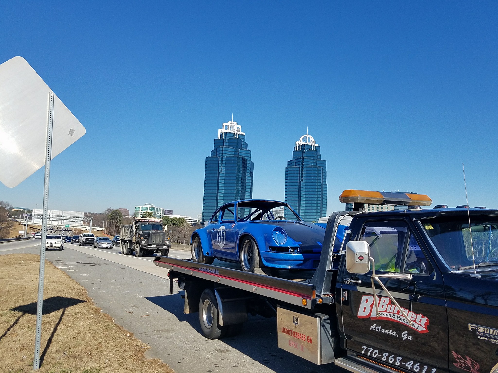 Blue race car on back of towing truck.