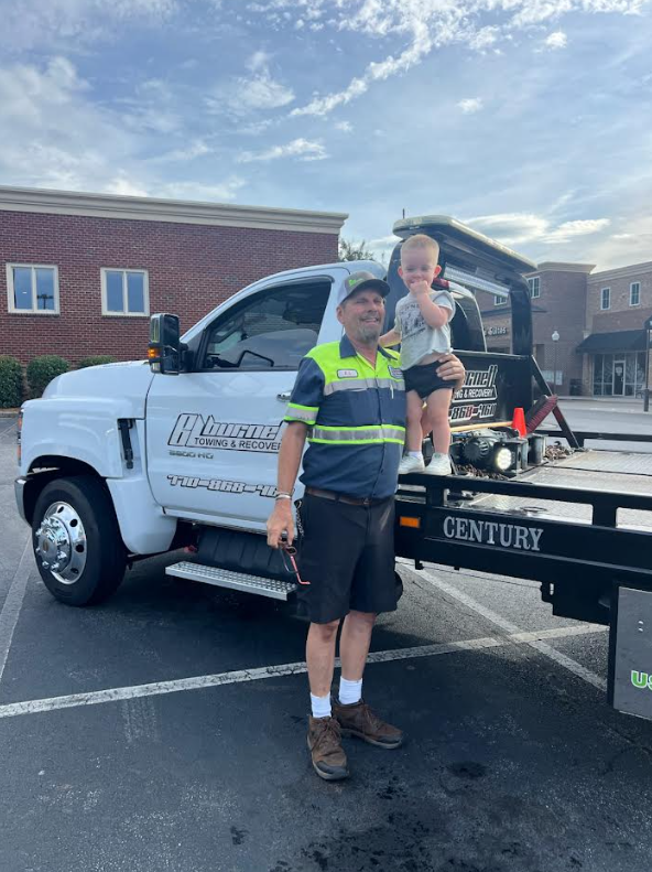 man and baby with tow truck.