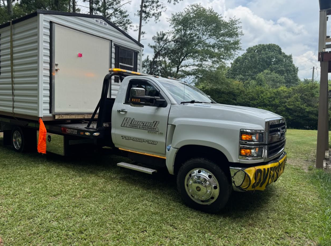 white storage unit on back of white tow truck