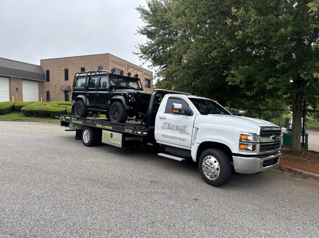 black jeep on back of tow truck.